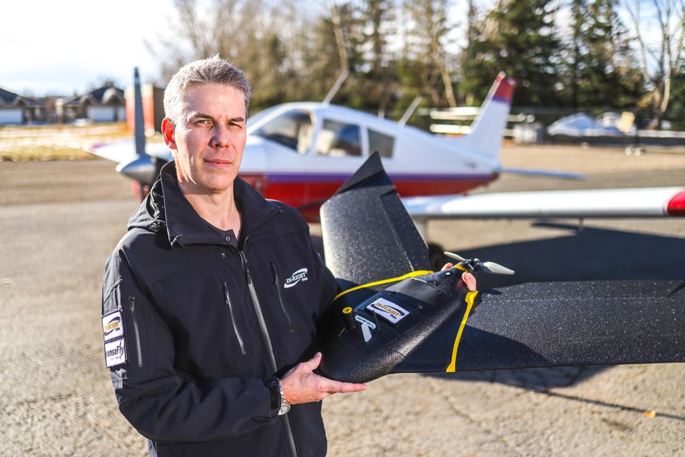 In-Flight Data founder and CEO Chris Healy poses with a senseFly eBee X fixed-wing drone on the Okotoks Airport tarmac on Oct. 30, 2020. The pilot has been using the drones to aid in fighting wildfires, and has just received authorization to fly them in synchronized swarms, an industry-first.