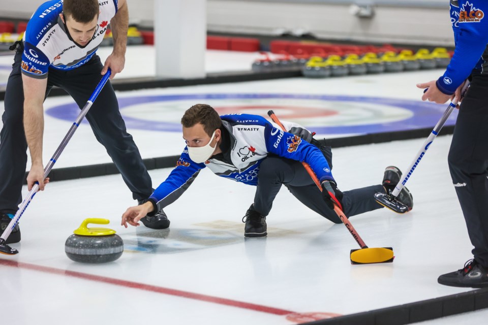 Brendan Bottcher throws to second Bradley Thiessen (left) and lead Karrick Martin in the ATB Okotoks Curling Classic final at the Okotoks Curling Club on Nov. 8. Bottcher won the final by a 6-5 score. (Brent Calver/Western Wheel)