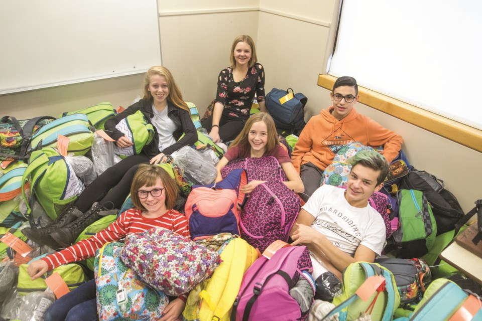 From left, Georgia Carter, Emma Davis, Adrian Pacione, and (front row,  Halla Grunow, Mia Marsh, and Sawyer Quinlan were among students who packed 500 backpacks in 2017. This year the campaign will focus on gift card and cash donations to adhere to COVID restrictions. (Brent Calver/Westerm Wheel)