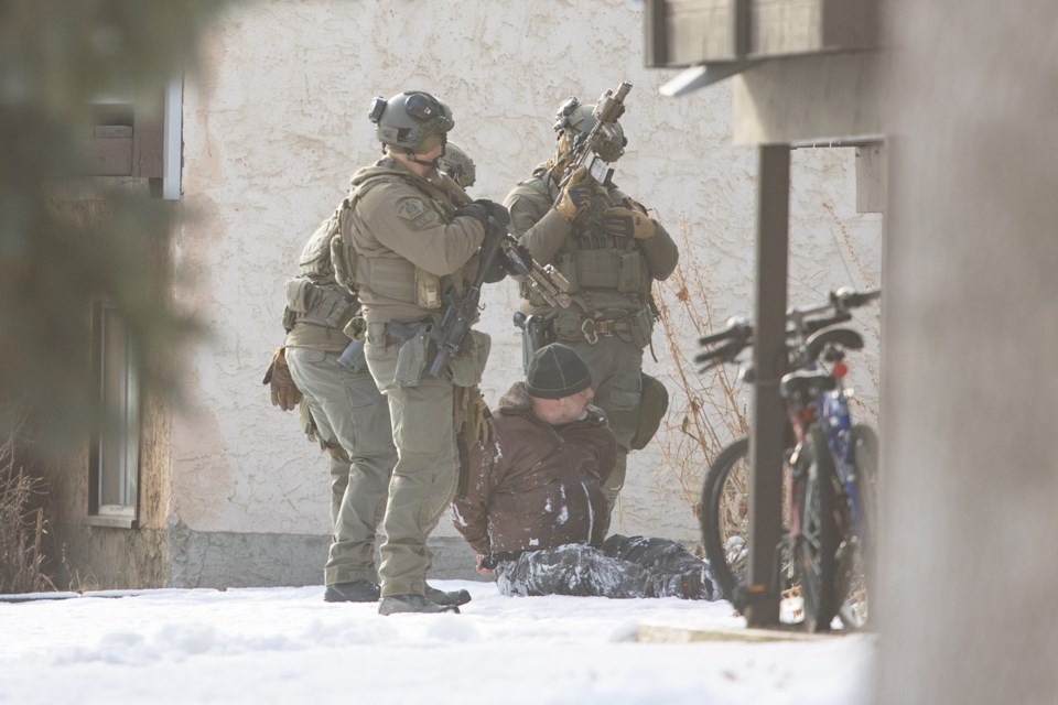 Members of the RCMP Emergency Response Team take a man into custody at a home on Stanley Ave. in Okotoks on Dec. 12. The incident began when the man was alleged to have fired a weapon through a window at a bailiff that was at the home to evict him. RCMP and their Emergency Response Team responded and surrounded the home before the man eventually gave himself up peacefully. (Brent Calver/Western Wheel)
