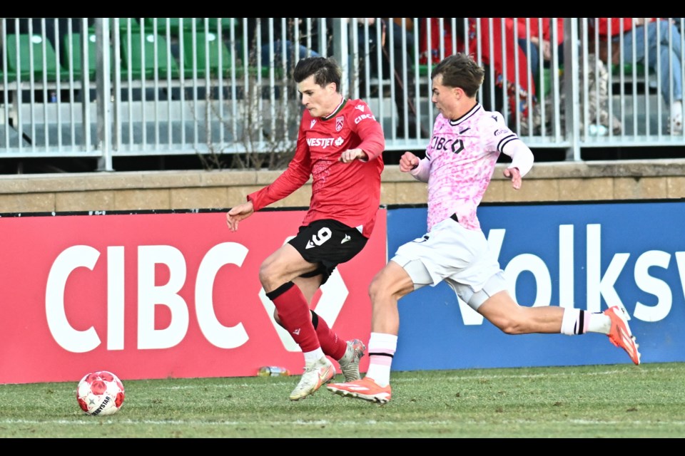 Cavalry FC’s Tobias Warschewski is defended by Vancouver FC’s Grady McDonnell during the May 3 Canadian Premier League match at Spruce Meadows’ ATCO Field. Warschewski scored twice in the 3-1 victory for the Cavs.