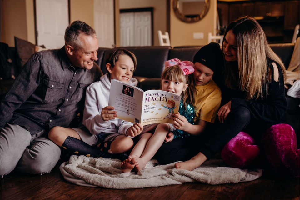 From left: Josh, Sawyer, Macey, Hudson and Caitlin Bangsund read Marvellous Macey, the Delightful Days together. The children's book was written by their mom, Caitlin, highlighting Macey's triumph over childhood cancer and her ability to live life to its fullest.