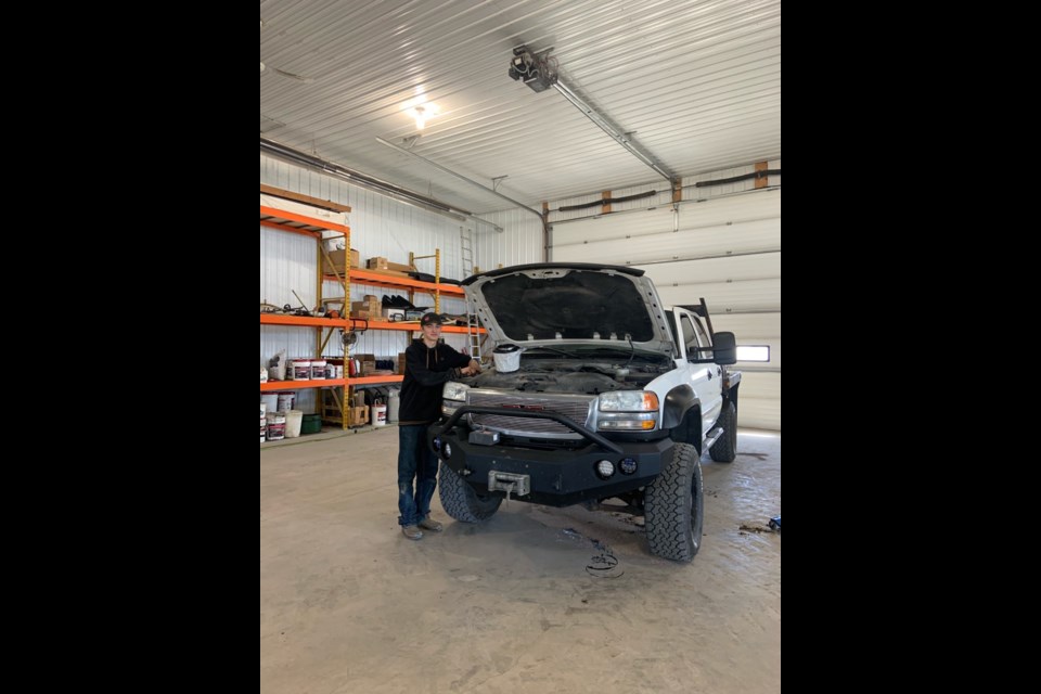 Carter Seney, works on a vehicle at the family farm near Blackie. Seney, was able to earn apprenticeship hours as a heavy-duty mechanic while taking the Registered Apprenticeship Program at St. Luke's Outreach Centre in Okotoks. (Photo submitted)