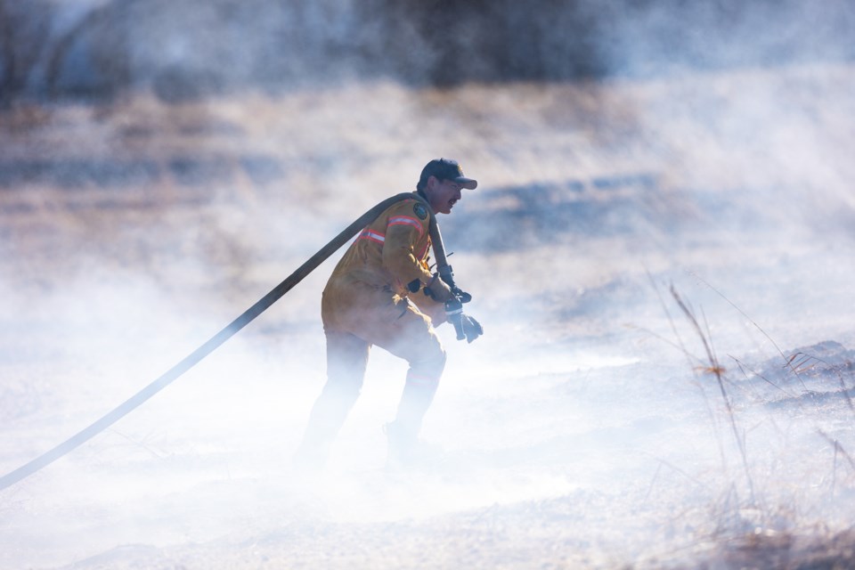 Fire crews from Foothills and Okotoks battle a grass fire west of DeWinton near 226 Ave. and 64 St. NW on March 20. Despite strong eastbound winds, the fire was suppressed before it spread to any other properties.