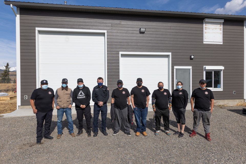 Eden Valley's newly recruited firefighters, along with Stoney Nakoda fire chief Mike Crawford (fourth from left) and addictions counsellor Joel Edey (second from left) stand in front of the new Nakoda Emergency Services fire hall in Eden Valley on April 7.