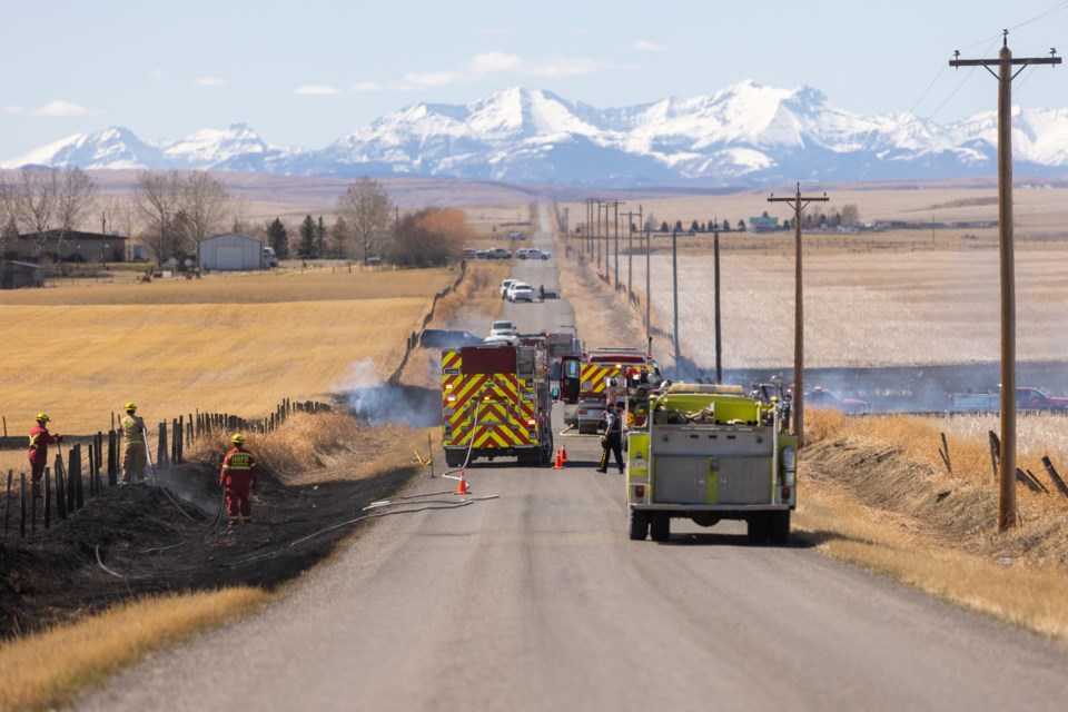 Fire crews battle a grass fire near 690 Ave. E just west of HWY 2 near Cayley on April 14. Firefighters were able to get the fire under control un under two hours with the help of neighbours who brought farm equipment and water trucks to assist.