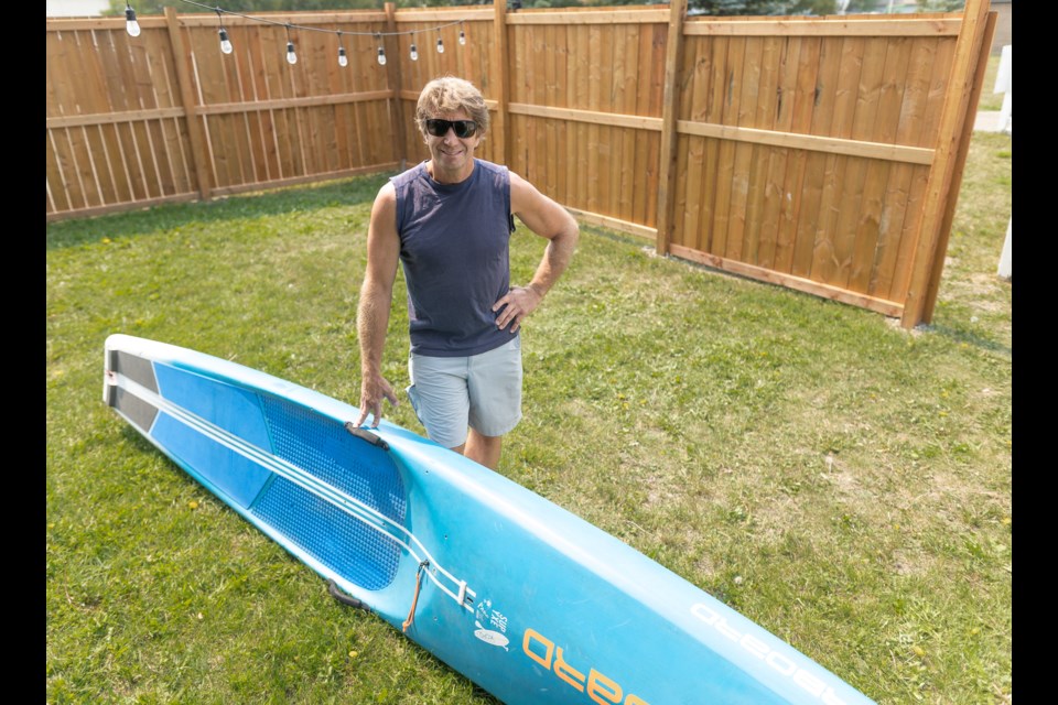 Greg Morris poses with his standup paddleboard in Black Diamond on July 30. Morris, along with son Jonah, founded SUP to the Core last spring, offering standup paddleboarding lessons on Chain Lakes Provincial Park.