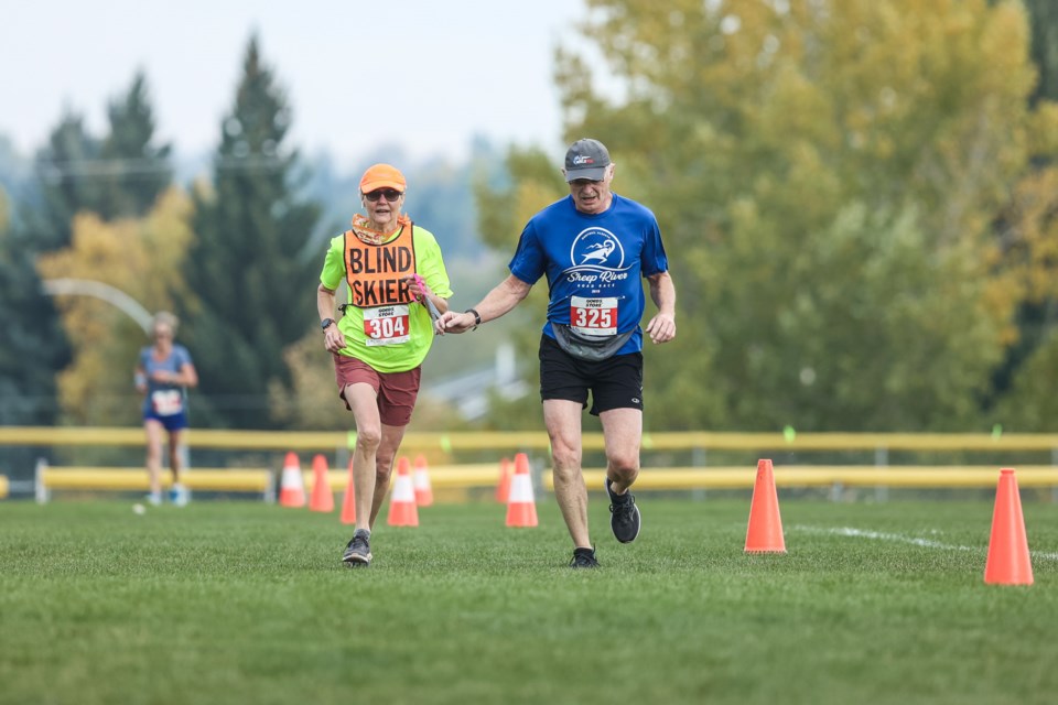 Barbara Bielinski, a visually-impaired runner, is assisted by Don Lee during the Sheep River Road Race 10k on Sept. 18.