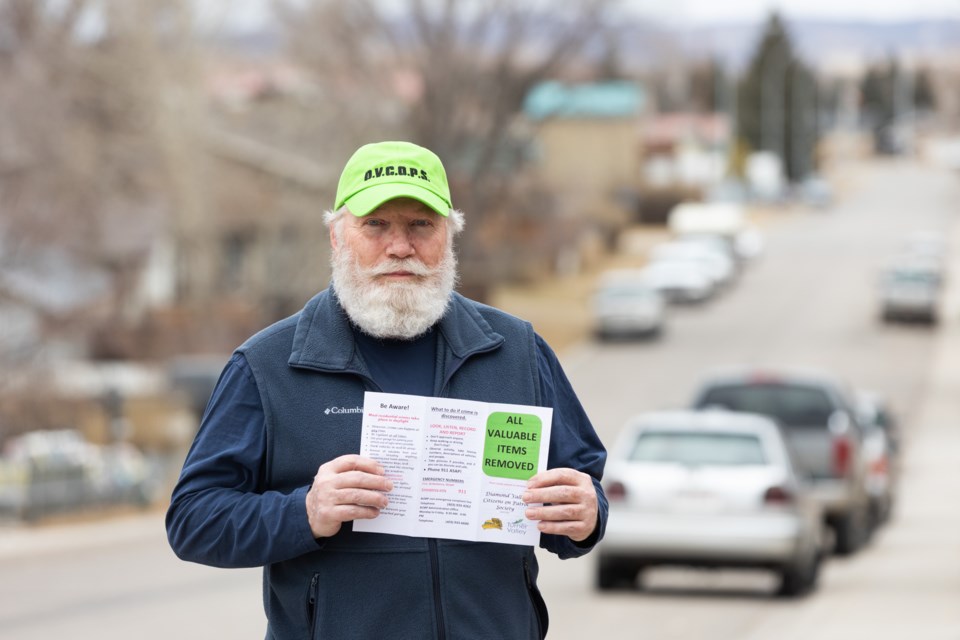 Ian Huffman of Diamond Valley Citizens on Patrol holds up a brochure about removing valuables from vehicles in Black Diamond on Nov. 12.