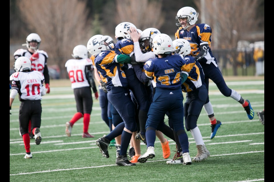 Rylan Neish, middle, is mobbed by teammates after his interception on the final play of the game as the Foothills Eagles knocked off the Chestermere Chiefs 10-3 in the CBFA Division III city championship on Nov. 2 at Hellard Field.
(Remy Greer/Western Wheel)