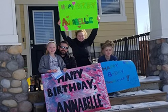 The Piraux family - Annabelle, Jason, Mandi and Alyssa - hold signs made by friends who participated in the birthday parade to celebrate Annabelle's 10th birthday on April 6. (Photo Courtesy of Shauna Way)