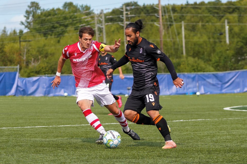 Cavalry FC centre-back Mason Trafford keeps an eye on Forge FC striker Mo Babouli during Forge's 1-0 win on Sept. 15. (CPL/Chant Photography)