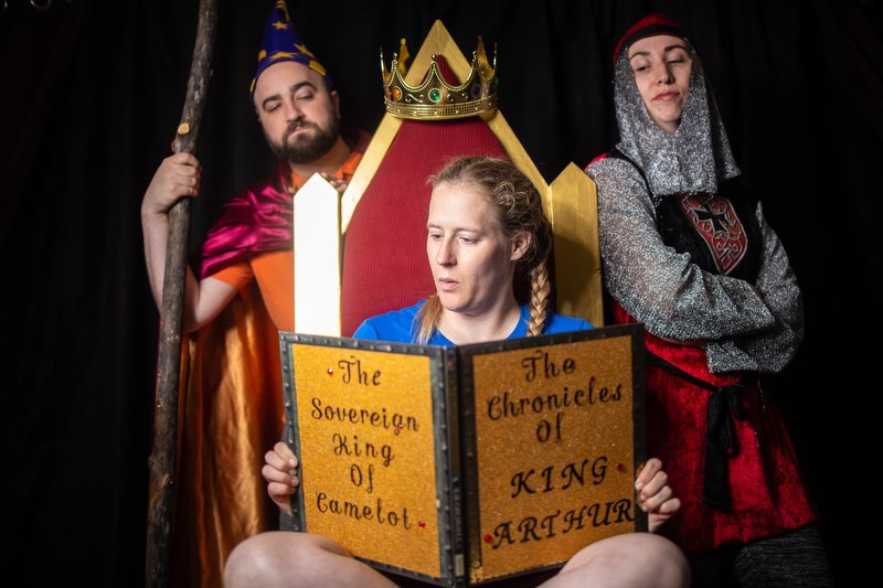 Kelly Malcolm, playing Win, is transported to a different world while reading the fantasy of King Arthur in a rehearsal for Goodger Pink Family Theatre's production of King Arthur.  (Photo by Brent Calver/Western Wheel)