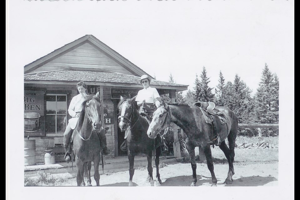 Two American tourists pose on horseback in front of the old Kew Store, which used to be a busy store and post office near Millarville, in the 1940s. The store no longer exists. (Photo courtesy of Roy Foster)
