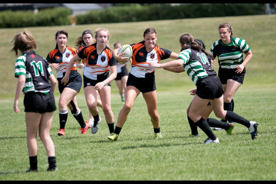 Foothills Lion Emily Slocombe fights through a tackle against the Calgary Saracens with teammates Charlize Koopman, Anna Greydanus and Wren Perras providing support. 
(Remy Greer/Western Wheel)