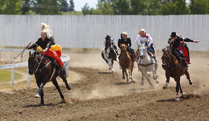 Erin Thompson, left, competes in the Ladies’ Sidesaddle Race at the 114th running of the Millarville Races on Canada Day. Thompson placed first in the race. (Photo by Devon Langille/Western Wheel)