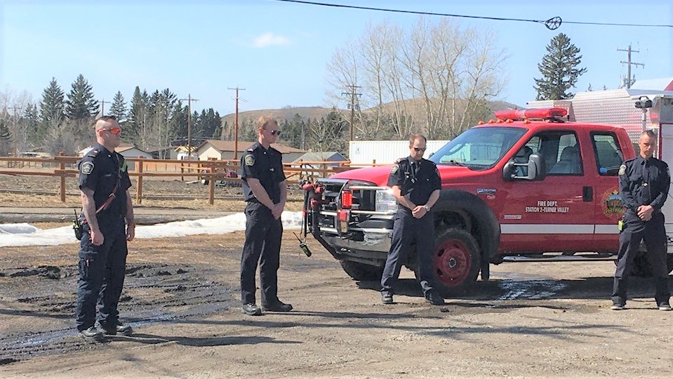 Firefighters, RCMP officers and other emergency personnel stand near St. George's Anglican Church in Turner Valley to mourn those killed in last weekend's mass shooting in rural Nova Scotia. (Tammy Rollie/Western Wheel)