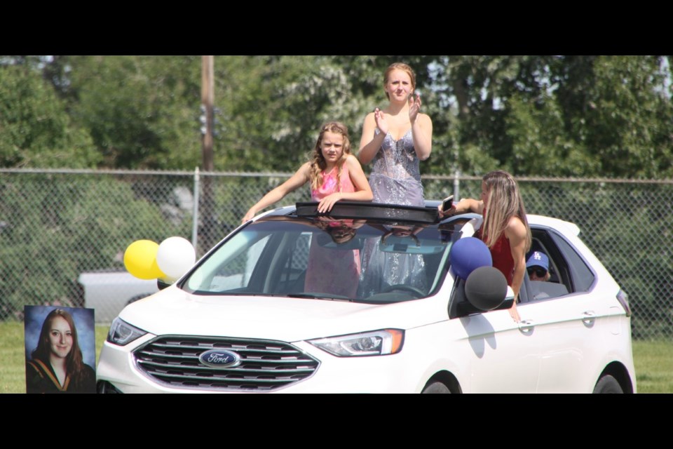 Graduate Kiera Bretzlaff and her sister Trinity, 11, watch the festivities from the sunroof, joined by mom Carla from the driver's side, during the Oilfields High School graduation ceremony on June 25. (Tammy Rollie/Western Wheel)
