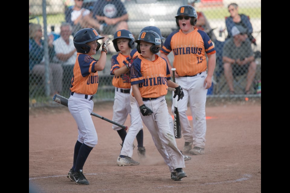 Outlaw Byron Thrift celebrates his inside the park grand slam with teammates Kruz deBoer, Cohen Padget and Simon Tonner in the provincial final at Wylie Park. Parkland edged Okotoks 16-15 in the championship match.
(Remy Greer/Western Wheel)