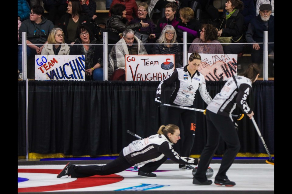 Team Vaughan skip Jodi Vaughan throws past a group of fans sporting signs during draw 5 of the 2020 Alberta Scotties at Murray Arena in Okotoks on Jan. 24. (Brent Calver/Western Wheel)