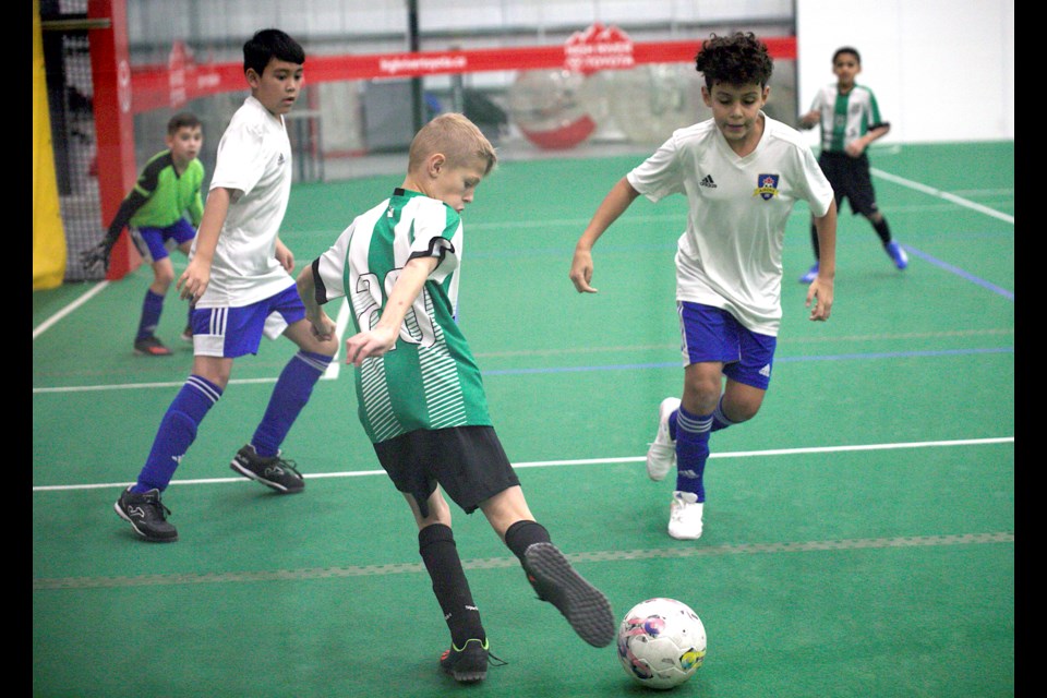 Okotoks United’s Theo Lippitt looks set up a cross versus the Airdrie FC Sounders during the bronze medal game of the boys U12 Tier 3 boarded division at the Anthem Communities Cup on Jan. 21 at the Cavalry FC Regional Field House in Aldersyde. Okotoks won bronze via a 5-1 victory.