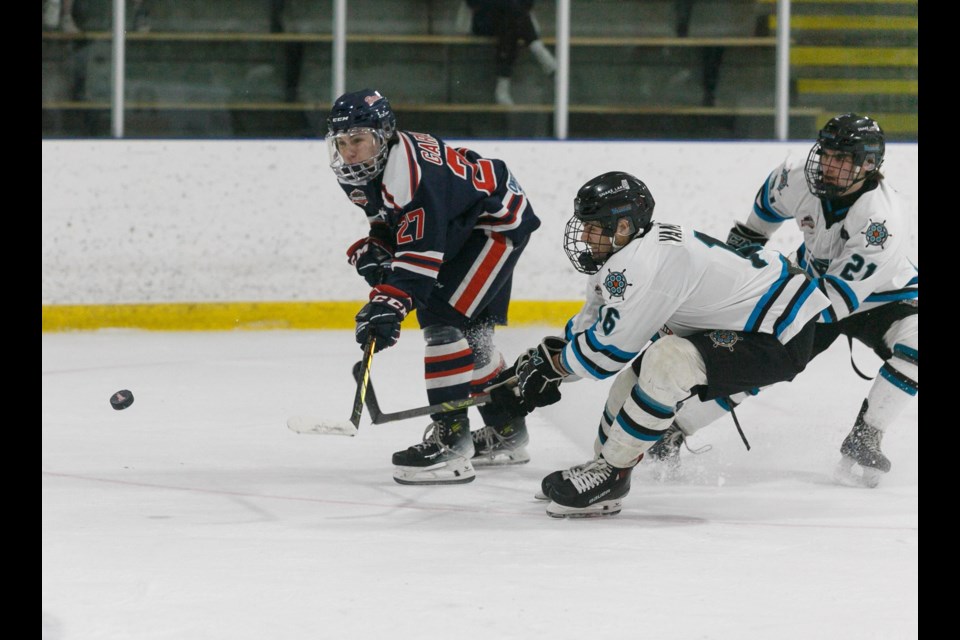 Carstar Okotoks Bisons forward Seamus Garagan lifts a backhand shot on goal with Sylvan Lake Wranglers Justin Vandermeer and Owen Callow defending during Okotoks’ 6-1 win on Feb. 10 at Murray Arena. 