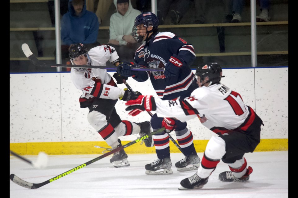 Carstar Okotoks Bisons forward Jady Shigehiro wins a puck battle in between a pair of Three Hills Thrashers defenders during Okotoks’ 6-2 win in Heritage Junior Hockey League action on Jan. 4 at the Murray Arena. 