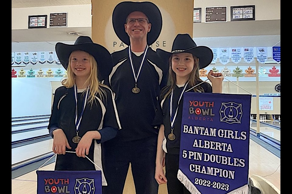 Elisha Delehay, left, and Elizabeth Honish, along with coach Kyle Honish celebrate after winning the Youth Bowl Alberta Fivepin Bantam Girls Doubles provincial title in Calgary. Delehay and Honish qualified for a return to the nationals where they were double medallists at the 2022 event. (Photo submitted)