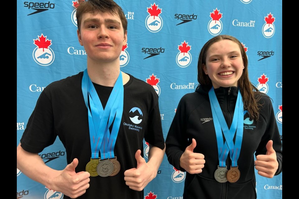 Okotoks Mavericks swimmers Wells Ginzer and Lucy Wiens pose with their combined six medals won at the Western Canadian Swimming Championships in Winnipeg. The Mavericks ranked 18th out of 67 clubs at the meet with its medal, top-eight and top-16 performances from its six athletes.