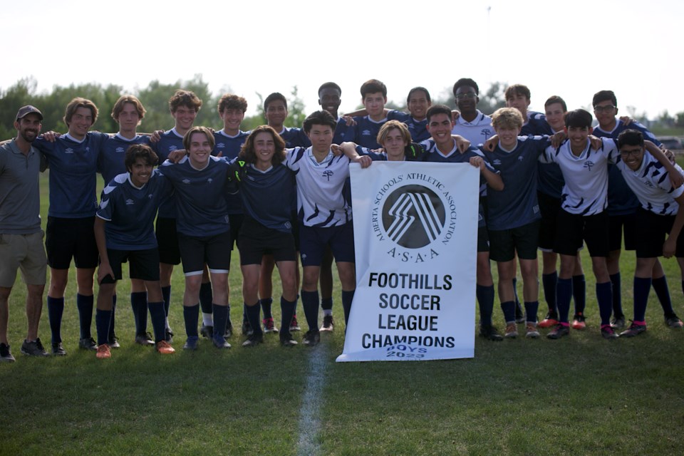The Strathcona-Tweedmsuir Spartans pose with the banner after defeating the HTA Knights 3-1 in the Foothills Athletic Council senior boys soccer final on June 5 at Bill Robertson Park. 