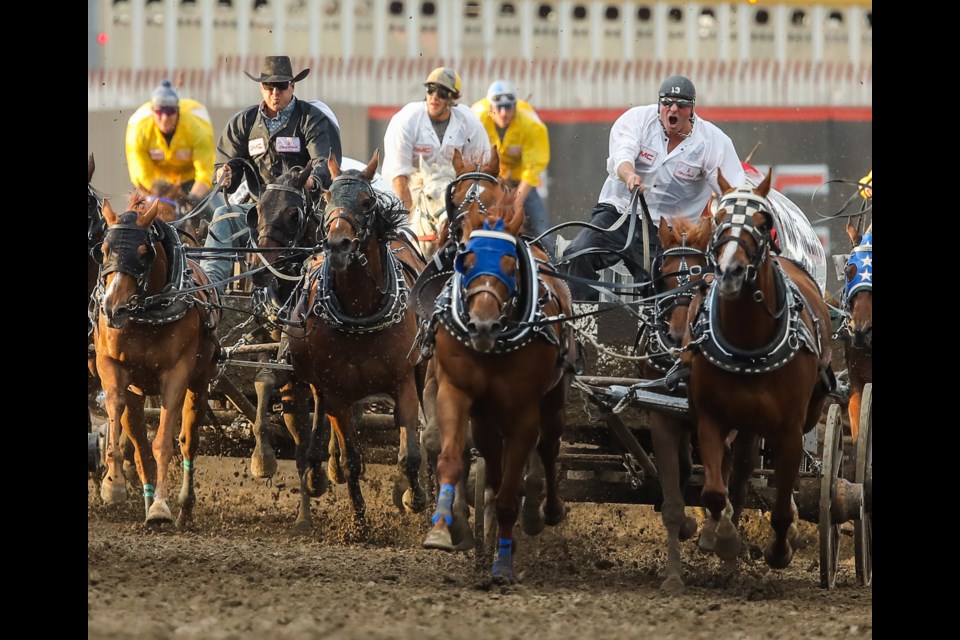 Foothills chuckwagon drivers Jordie Fike, left, and Jason Glass speed southbound and down towards the finish on Day 2 of the GMC Rangeland Derby at the Calgary Stampede on July 6. (BRENT CALVER/Western Wheel)