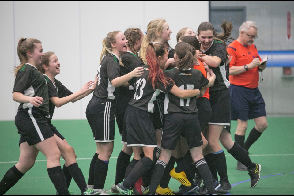 Okotoks United celebrates with goalkeeper Maria Regner after defeating Calgary Foothills 1-0 in a penalty shootout to win the U15 girls Tier II division of the Anthem United Communities Cup on Jan. 19 at Crescent Point Regional Field House.
(Remy Greer/Western Wheel)