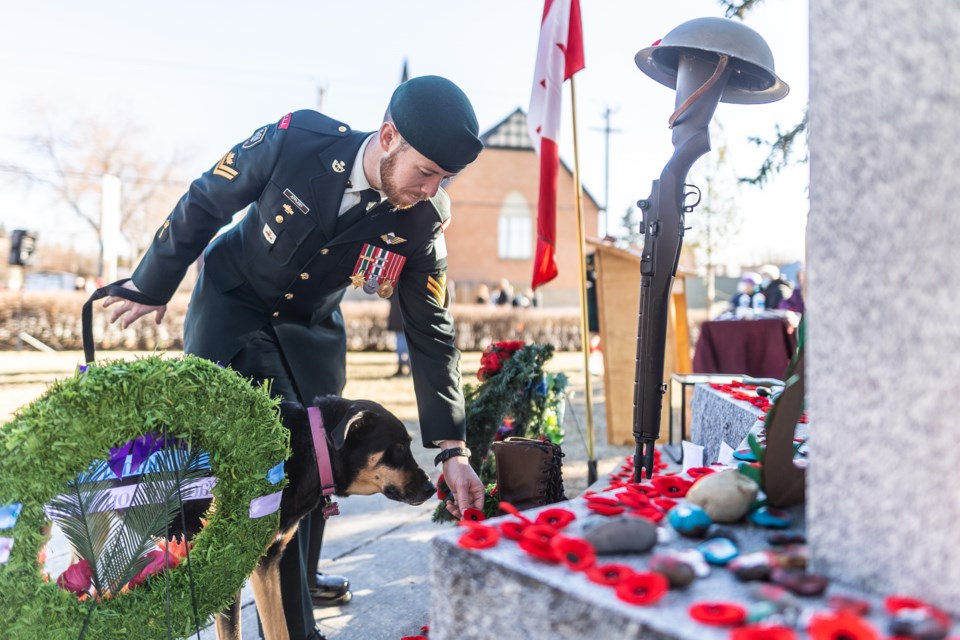 Master Cpl. Byron Appleby, accompanied by his dog Bailey, places his poppy on the Okotoks cenotaph following a ceremony marking Remembrance Day on Nov. 11.