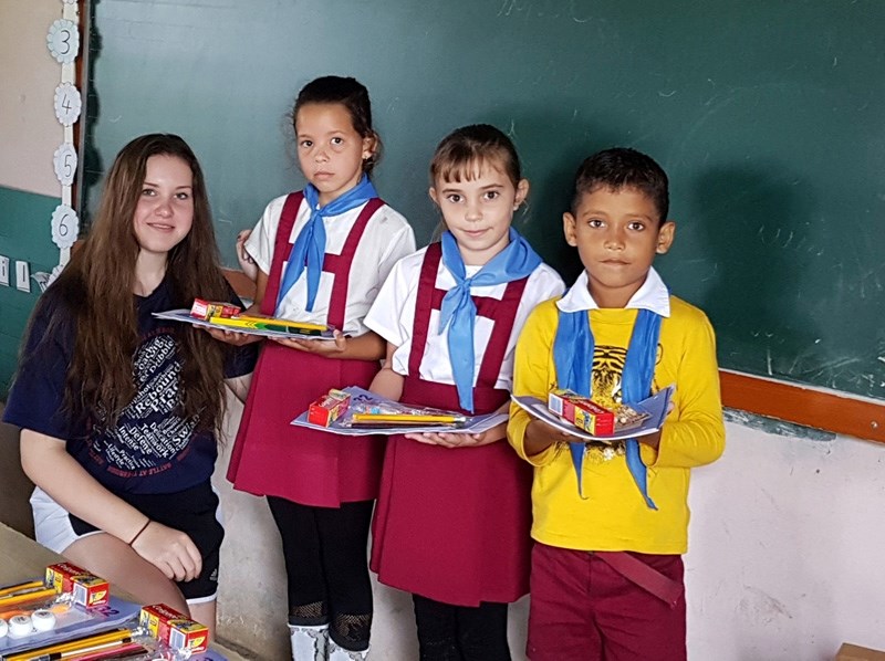 Vanessa Jelic presents some backpacks she collected to give to students at a Cuban elementary school.