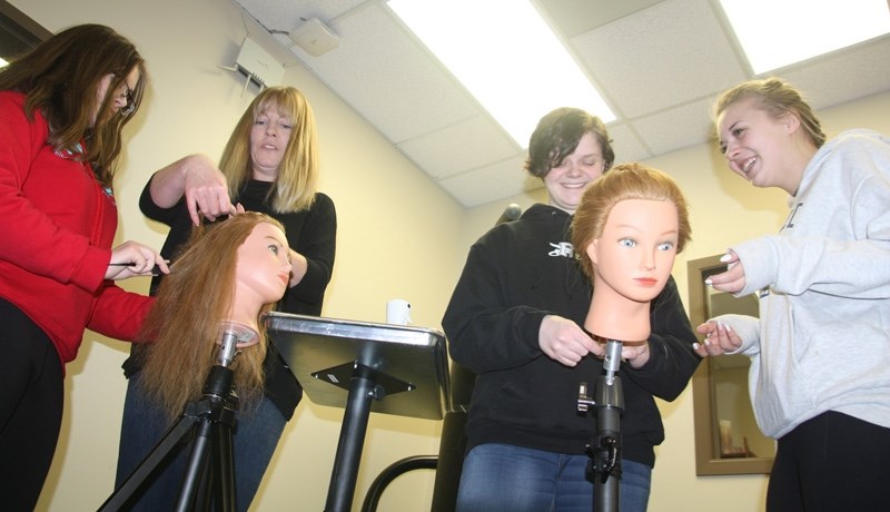 Crystal Benz of Shear Madness hair design shares some of her expertise with St. Luke&#8217; s Outreach School as part of the school&#8217; s Cosmetology course. From left,