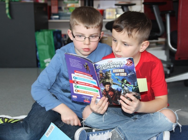 Reid Brown and Jaxson Cleroux share the excitement of reading Guardians of the Galaxy during the What I Need (WIN) program at Cayley School on Jan. 25.