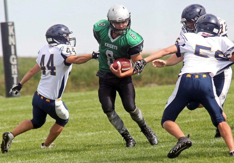 Quarterback Cameron Fietz, here evading tacklers as a member of the Holy Trinity Academy Knights, committed to the University of British Columbia Thunderbirds where he will
