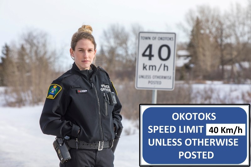 Okotoks Municipal Enforcement officer Alisha Eisenberg stands by one of the Town of Okotoks&#8217; old 40 km/h signs posted at town boundaries. Inset: The Town is considering 