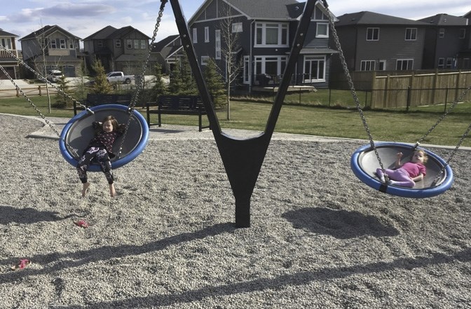 Ava Halpin, left and her sister, Ashlyn, 4, who has cerebral palsy, try out the disc swings at a playground in Mountainview. While the swings are beneficial for children with 