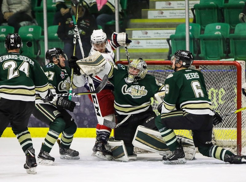 Okotoks Oilers goalie Riley Morris pushes out a rebound as Nolan Thompson of the Brooks Bandits lurks dangerously in front of goal during regular season action between the