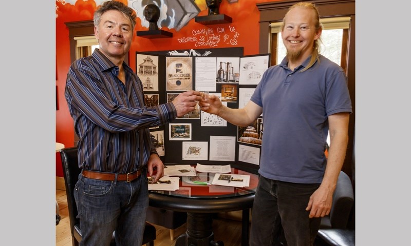 John Hromyk, left, and Brett Schonkess welcome community members curious about the proposed Bragg Creek Distillery during an open house at the Brain Bar in Bragg Creek on
