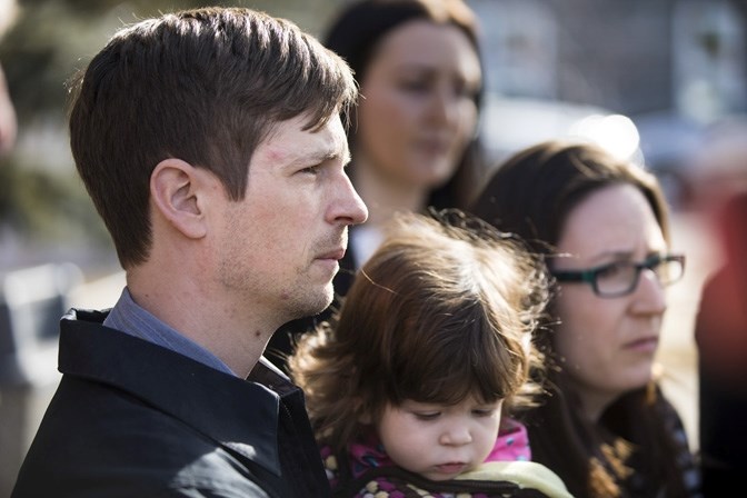 Edouard Maurice and his family look out on a scrum of media and supporters as his attorney Tonii Roulston speaks of the frustration over delays of evidence disclosure outside 