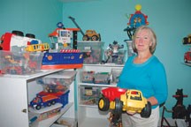 Emily Walker, Okotoks Toy Library board member, shows off some of the library&#8217;s selection of toys. The organization may have found a solution for its financial woes and 