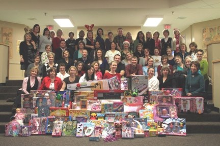 The Good Shepherd School staff stands with the presents they received through their Secret Santa exchange Friday. All the toys, which were given to the inner child of each