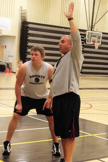 Holy Trinity Academy coach Sam Aiello instructs a drill with post Alex Lorenz during a December practice. HTA will play host to the annual Knights Classic Tournament on Jan.