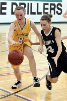 Oilfields Drillers Carly Hoar and Holy Trinity Academy Knight Riley Pearson battle for the ball in the Knights&#8217; 69-43 victory Jan. 5 in Black Diamond.
