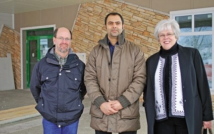 Construction manager Todd Harkness, librarian Muhammad Zia-ul-Haque, and library board chair Diane Osberg stand at the entrance to the new Sheep River Library in Turner