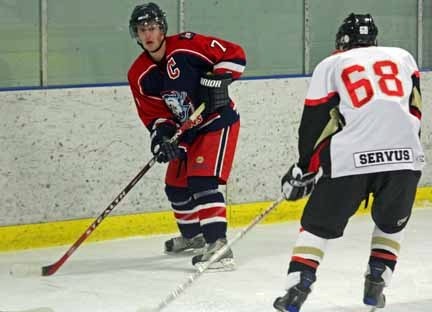 Okotoks Bisons captain Derek Schlamp (left) looks for a man in front during the Bisons&#8217; 8-5 victory over the Ponoka Stampeders on Sunday at the Murray Arena.