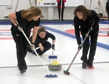 Gail Giroux of the Debbie Miller rink comes out of the hack in the A final of the Okotoks Ladies Bonspiel Sunday. Kerry Imler and Susan Lypkie prepare to sweep the rock. The