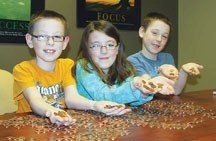 Captured with some of their pennies aplenty are members of the Harder family from left, Zach (9), Hayley (8) and Clayton (9). They are collecting the coins to aid